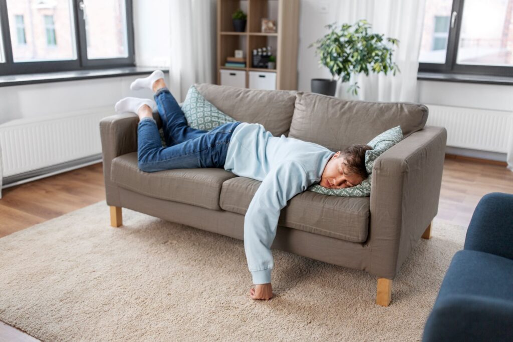 Mann schläft auf zu kleinem Sofa