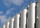 Mehrere Edelstahlsilos unter blauem Himmel – industrielle Lagerung mit moeglichem Siloschlauch-Einsatz