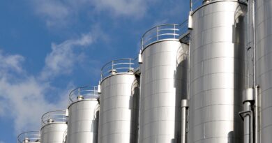 Mehrere Edelstahlsilos unter blauem Himmel – industrielle Lagerung mit moeglichem Siloschlauch-Einsatz