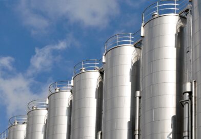 Mehrere Edelstahlsilos unter blauem Himmel – industrielle Lagerung mit moeglichem Siloschlauch-Einsatz